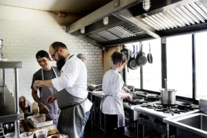 Chefs en cuisines pro devant les hottes